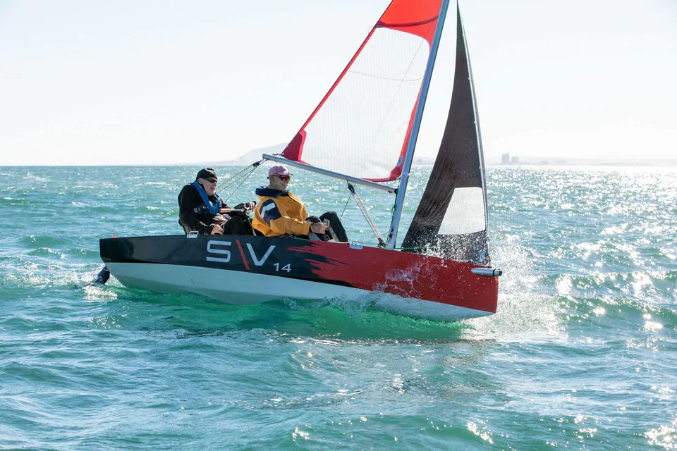 Two sailors using supportive seats on a Fareast SV14 under sail