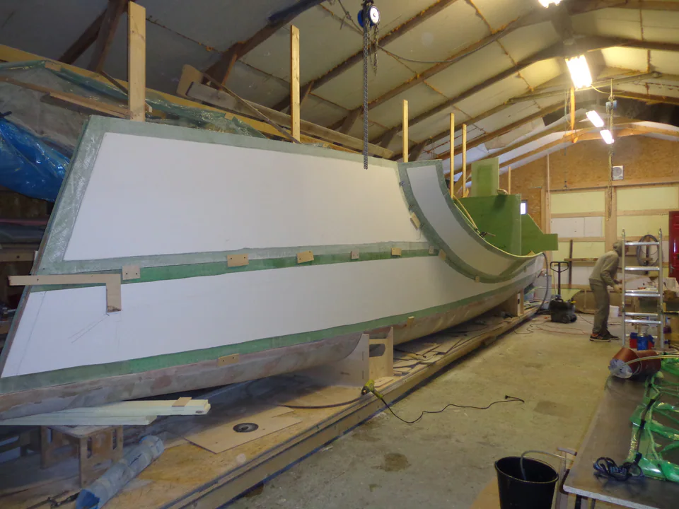 Composite yacht hull section being faired in a workshop