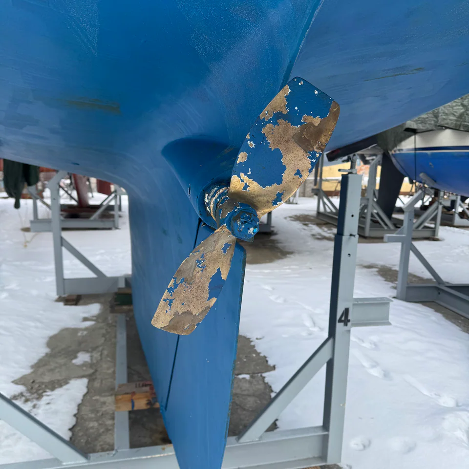 Propeller and underwater hull of a sailing yacht ashore