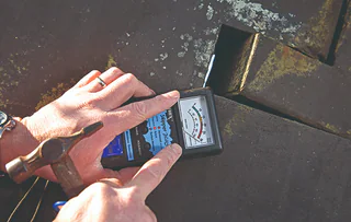 Moisture meter held against a yacht hull surface